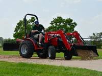 Man pouring gravel with a 2019 Mahindra Max 26XL 4WD HST