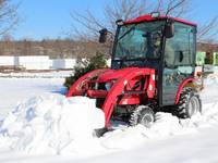 Man plowing snow with a 2019 Mahindra EMAX 25S HST Cab