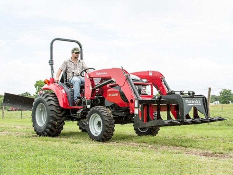 Man riding a Mahindra 1533 HST Tractor on a grass field